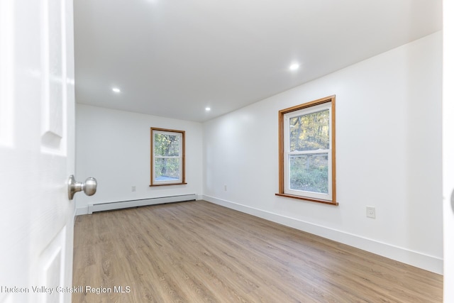 empty room featuring light hardwood / wood-style floors and baseboard heating