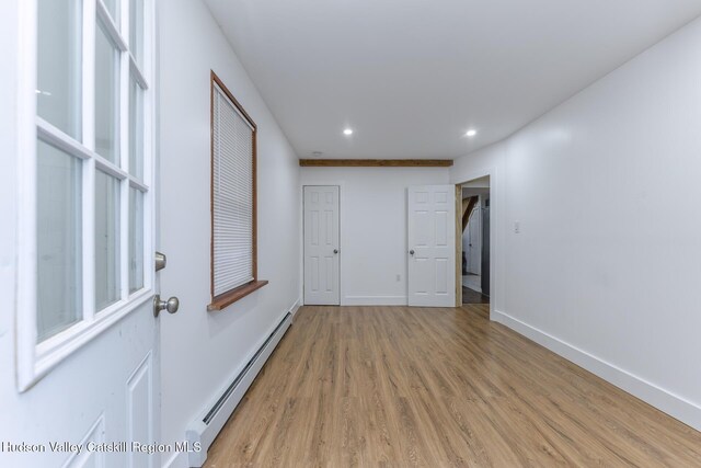 interior space with baseboard heating and wood-type flooring