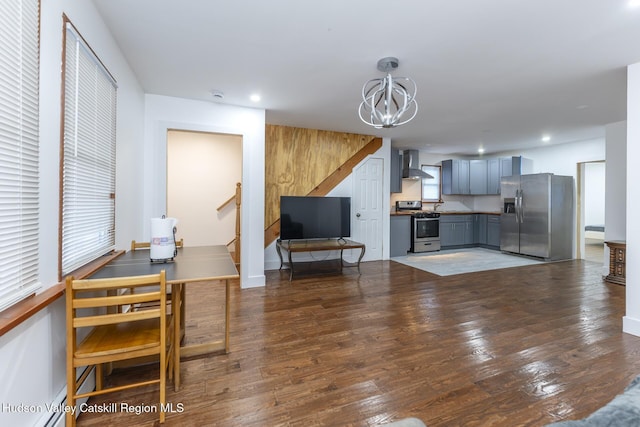 living room featuring a baseboard heating unit, an inviting chandelier, and dark wood-type flooring