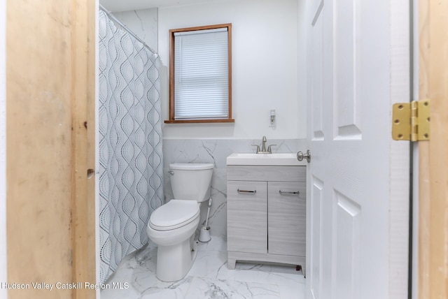 bathroom featuring vanity, tile walls, and toilet