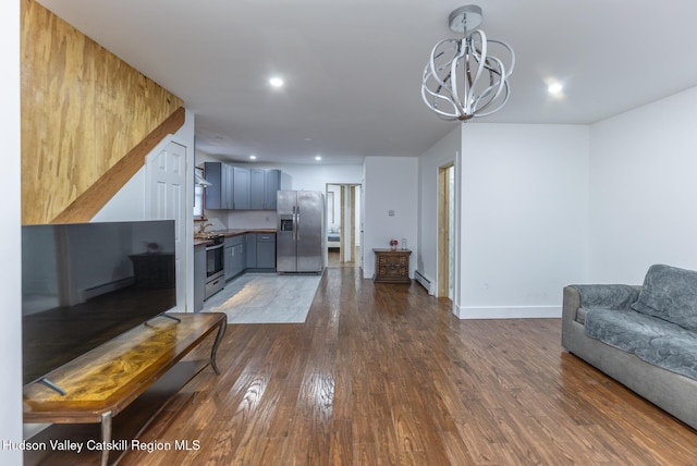 living room with sink, a baseboard radiator, a chandelier, and dark hardwood / wood-style floors