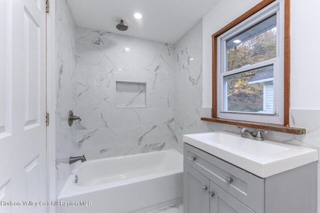 bathroom with vanity and tiled shower / bath