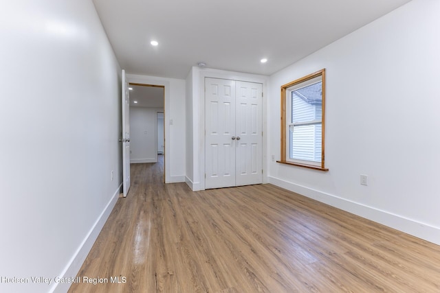 unfurnished bedroom with a closet and light hardwood / wood-style flooring