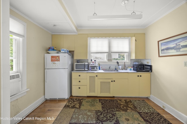 207 Maple Ave, Germantown, NY 12526 - kitchen with freestanding refrigerator, cream cabinetry, stainless steel microwave, light wood finished floors, and ornamental molding