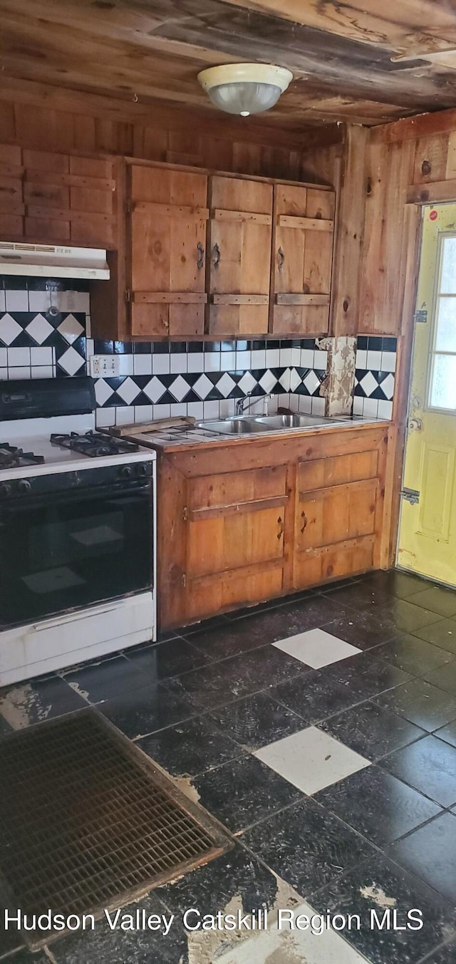 kitchen featuring tasteful backsplash, wood ceiling, range with gas cooktop, and wooden walls