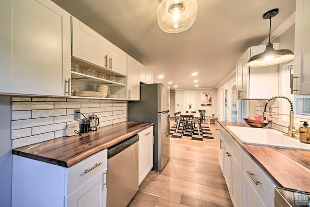 871 Mail Route Rd, Ashland, NY 12407 - kitchen featuring appliances with stainless steel finishes, a sink, butcher block countertops, light wood finished floors, and decorative backsplash