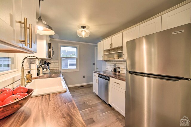 871 Mail Route Rd, Ashland, NY 12407 - kitchen featuring appliances with stainless steel finishes, tasteful backsplash, light wood-type flooring, a sink, and white cabinets