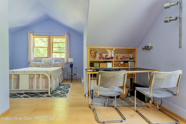 bedroom featuring lofted ceiling and light wood-type flooring