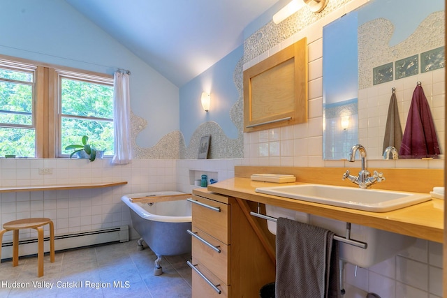 bathroom with lofted ceiling, tile patterned floors, sink, tile walls, and a baseboard radiator