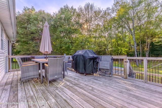 wooden deck featuring outdoor dining space and grilling area