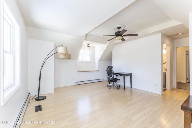 additional living space with a baseboard heating unit, visible vents, and wood finished floors