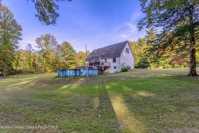 view of yard with a covered pool and a wooden deck