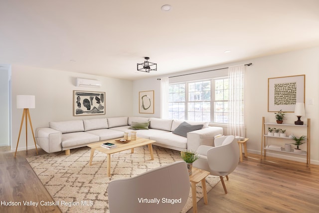 living area with a wall unit AC, baseboards, and wood finished floors