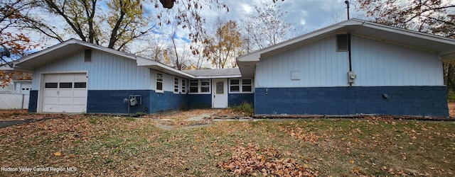 view of side of home featuring a garage and a lawn