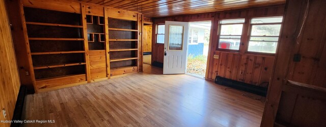 interior space featuring hardwood / wood-style flooring, wooden walls, and wooden ceiling