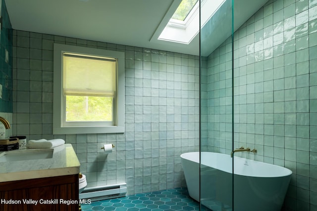 35 Jilroy Ln, Spencertown, NY 12165 - full bathroom featuring tile walls, baseboard heating, a freestanding tub, a skylight, and vanity