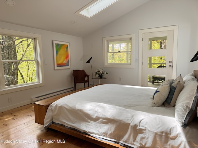 35 Jilroy Ln, Spencertown, NY 12165 - bedroom featuring vaulted ceiling, a baseboard heating unit, multiple windows, a skylight, and light wood-style flooring
