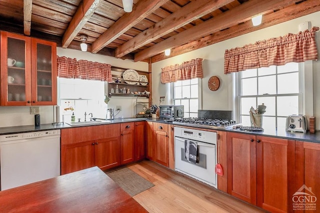 kitchen with white appliances, a sink, wooden ceiling, light wood-style flooring, and dark countertops
