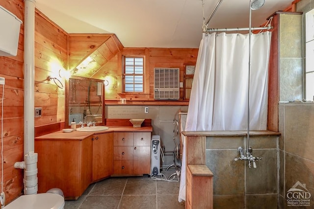 full bath with a shower with curtain, toilet, vanity, tile patterned floors, and wood walls