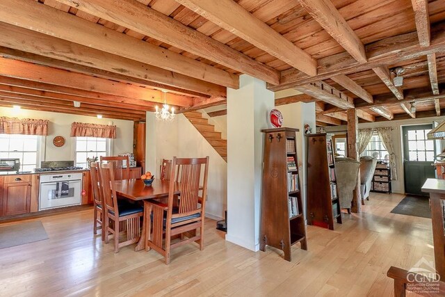 dining room with wooden ceiling, beam ceiling, light wood finished floors, stairs, and a chandelier