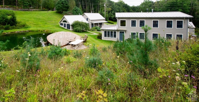 view of front of house with metal roof and a front lawn