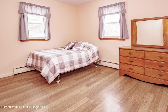 bedroom with light wood-style floors and a baseboard radiator