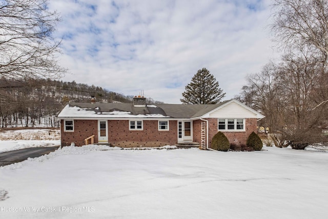 ranch-style home featuring entry steps and brick siding