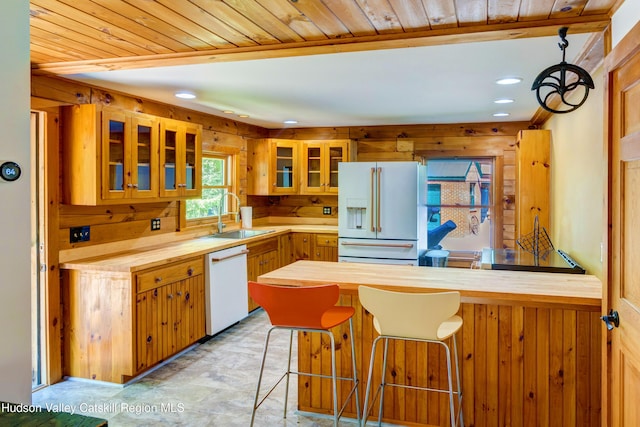 kitchen with butcher block counters, white appliances, sink, and wood ceiling