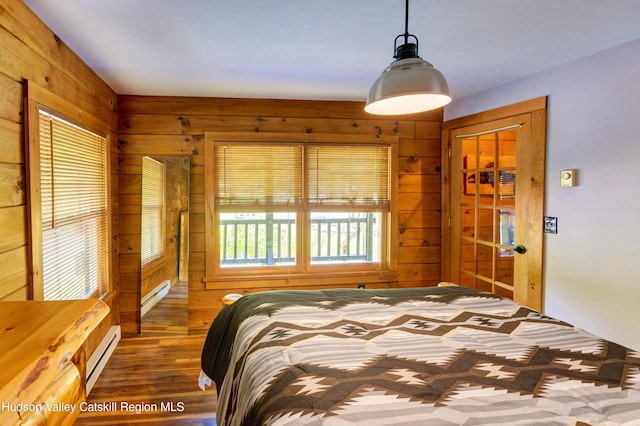 bedroom with dark hardwood / wood-style flooring, a baseboard radiator, and wood walls