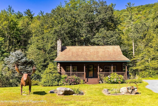 log home featuring a porch and a front lawn