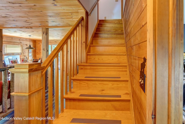 stairs with wood walls, hardwood / wood-style floors, and wood ceiling