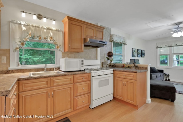 1055 Rte 212, Saugerties, NY 12477 - kitchen with a peninsula, white appliances, light wood-type flooring, under cabinet range hood, and backsplash