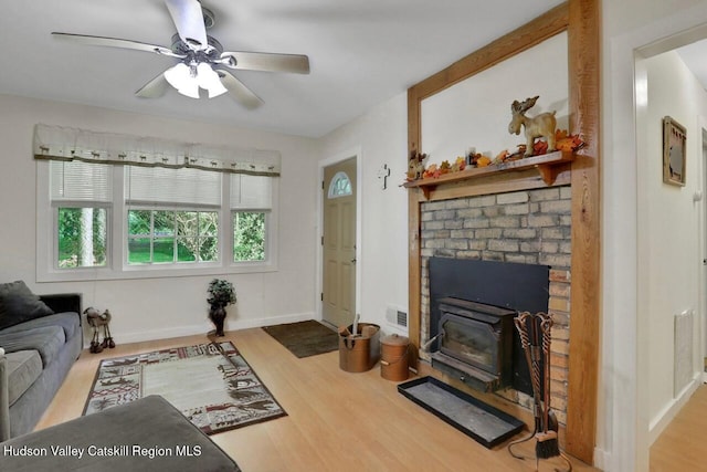 1055 Rte 212, Saugerties, NY 12477 - living area featuring a wood stove, wood finished floors, and a ceiling fan