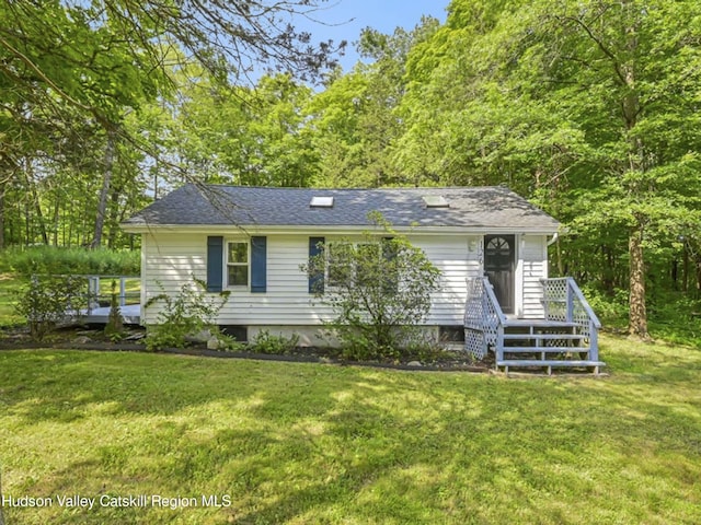 single story home featuring a wooden deck and a front yard