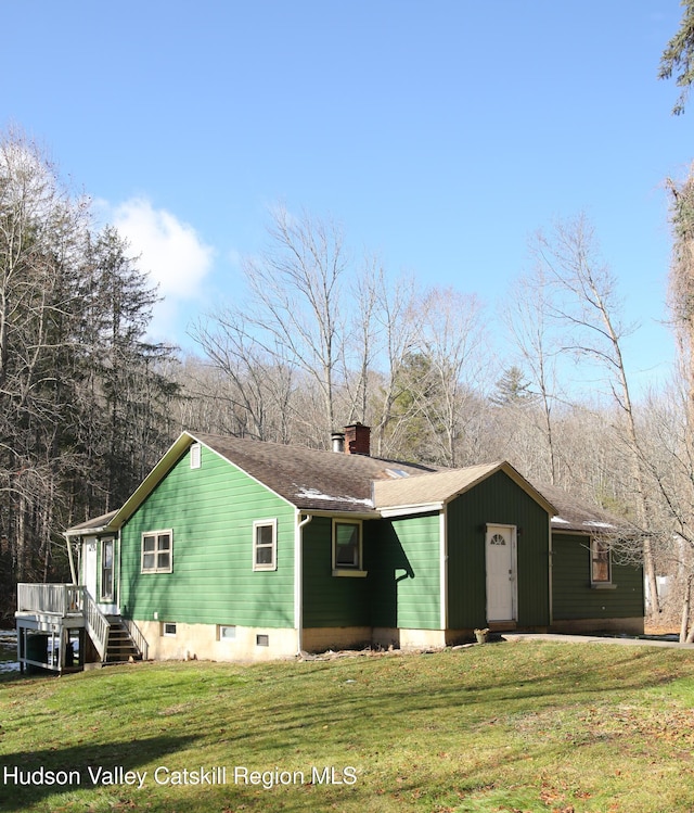 exterior space with a wooden deck and a front lawn