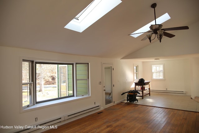 interior space featuring baseboard heating, a skylight, ceiling fan, and hardwood / wood-style flooring