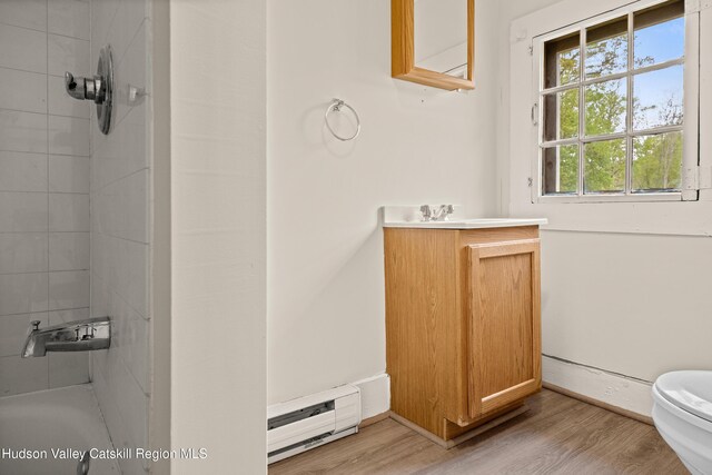 1 Green St, Gilbertsville, NY 13776 - full bathroom featuring a baseboard radiator, wood finished floors, toilet, and vanity