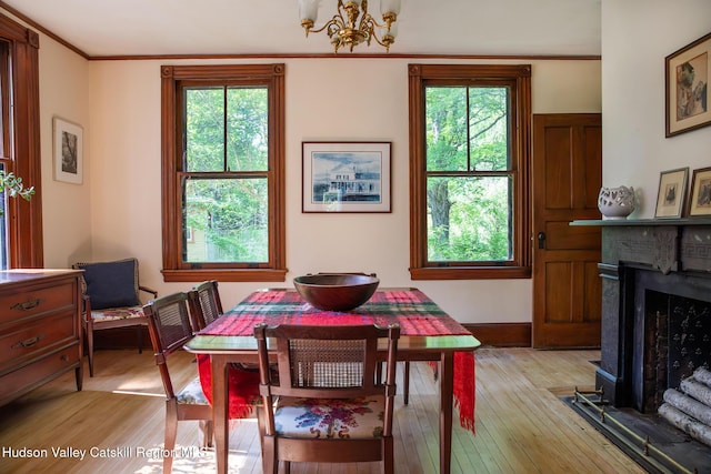 121 Birch Creek Rd, Pine Hill, NY 12465 - dining space with a fireplace with flush hearth, light wood finished floors, a chandelier, plenty of natural light, and crown molding