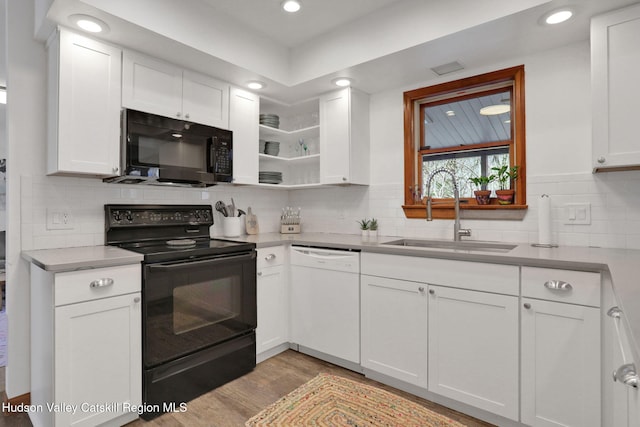 kitchen featuring white cabinets, a sink, black appliances, and wood finished floors