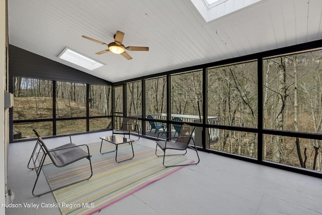 unfurnished sunroom with floor to ceiling windows, lofted ceiling with skylight, and a ceiling fan
