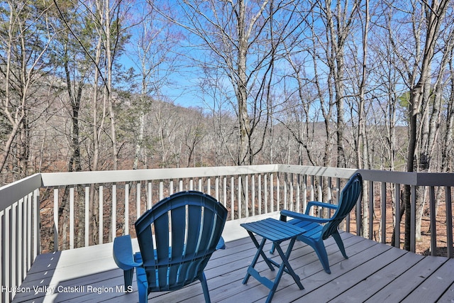 wooden terrace featuring a wooded view