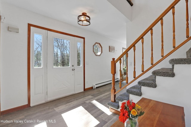 entryway with wood finished floors, baseboards, stairway, and baseboard heating