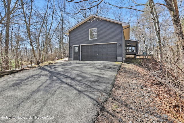 view of side of property with driveway and a garage