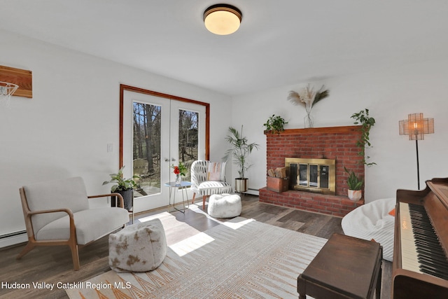 living room with french doors, a fireplace, and wood finished floors