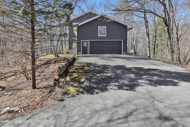 view of home's exterior featuring a garage and aphalt driveway