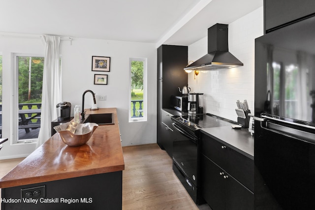 2064 County Highway 8, Denver, NY 12421 - kitchen with black appliances, wall chimney range hood, dark cabinetry, wood counters, and tasteful backsplash