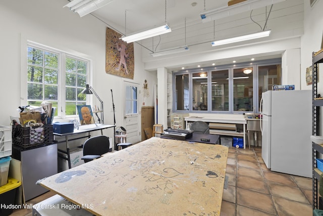 253 Upper Byrdcliffe Rd, Woodstock, NY 12498 - kitchen with freestanding refrigerator, a towering ceiling, tile patterned floors, and light stone counters