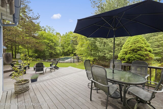 253 Upper Byrdcliffe Rd, Woodstock, NY 12498 - wooden deck with outdoor dining space, a pool, and a lawn