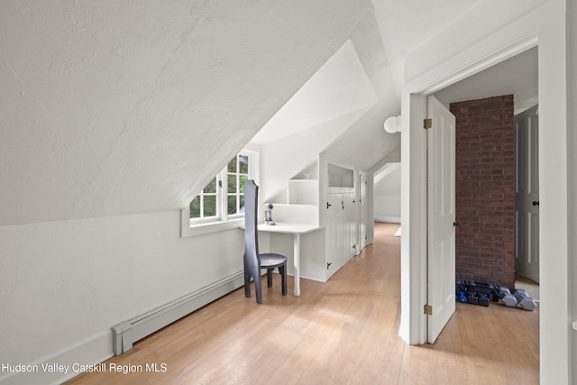 253 Upper Byrdcliffe Rd, Woodstock, NY 12498 - additional living space with wood finished floors, vaulted ceiling, a textured ceiling, a baseboard heating unit, and baseboards