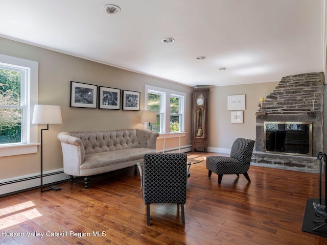 236 Spillway Rd, West Hurley, NY 12491 - living area featuring baseboard heating, hardwood / wood-style floors, a stone fireplace, and baseboards